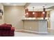 Basement kitchenette featuring wood cabinets, ample counter space, and modern pendant lighting at 5683 Fig Way, Arvada, CO 80002