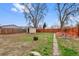 Spacious backyard with a shed, garden beds, wood fence and fire pit at 1530 W Berkeley Pl, Denver, CO 80221