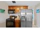 Well-equipped kitchen boasts stainless steel appliances, dark cabinetry, and efficient layout at 1530 W Berkeley Pl, Denver, CO 80221