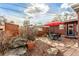 Serene backyard featuring a stone-paved patio with dining set and a red umbrella at 1370 Upham St, Lakewood, CO 80214