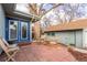 Relaxing patio area with a blue door, wooden chairs, and a large shade tree at 1370 Upham St, Lakewood, CO 80214