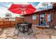 Cozy backyard patio with red umbrella and dining table at 1370 Upham St, Lakewood, CO 80214