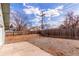 Large backyard with a mix of concrete, gravel, and a wooden fence, offering space and privacy at 1370 Upham St, Lakewood, CO 80214