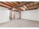 Spacious unfinished basement area with painted walls, carpeted floors, and exposed wooden beams at 1370 Upham St, Lakewood, CO 80214