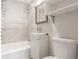 Compact bathroom featuring a shower-tub combo with tiled walls, and a modern vanity at 1370 Upham St, Lakewood, CO 80214