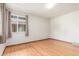 Empty bedroom featuring pristine hardwood floors, a large window, and neutral walls at 1370 Upham St, Lakewood, CO 80214