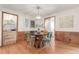 Elegant dining room featuring hardwood floors, wood-paneled walls, and modern lighting fixtures at 1370 Upham St, Lakewood, CO 80214