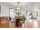 Bright dining room featuring stylish lighting, wood-paneled walls, and an open layout to kitchen at 1370 Upham St, Lakewood, CO 80214