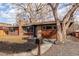 Inviting brick home featuring a well-kept lawn, mature trees, and a charming stone walkway at 1370 Upham St, Lakewood, CO 80214