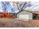 View of the detached one car garage and a rear deck surrounded by mature trees at 1370 Upham St, Lakewood, CO 80214