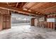 Open garage with wooden beams, concrete floor, and built-in storage solutions at 1370 Upham St, Lakewood, CO 80214