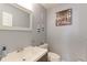 Quaint powder room with decorative accents, a white sink, and a neutral color palette at 13068 Harrison Dr, Thornton, CO 80241