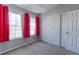 Cozy bedroom featuring large windows with pink curtains and a spacious closet with white doors at 13068 Harrison Dr, Thornton, CO 80241