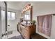 Bright bathroom featuring a wooden vanity, large mirror, and walk-in shower at 2005 Tabor Dr, Lakewood, CO 80215
