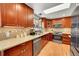 Modern kitchen with stainless steel appliances, granite countertops, and wooden cabinets at 2005 Tabor Dr, Lakewood, CO 80215