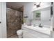 Updated bathroom with shower featuring glass doors, bright vanity, and floating shelves at 3082 S Wheeling Way # 410, Aurora, CO 80014