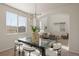 Sun-filled dining area with glass table, stylish chairs, and modern light fixture open to living room at 1936 Alpine Dr, Erie, CO 80516