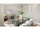 Bright dining area featuring modern lighting, glass table, and opens into living area at 1936 Alpine Dr, Erie, CO 80516