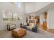Bright open-concept living room featuring large windows, and hardwood floors leading to kitchen at 1936 Alpine Dr, Erie, CO 80516