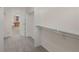 Carpeted walk-in closet featuring built-in shelving and rod and view to bathroom at 1936 Alpine Dr, Erie, CO 80516