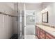 Modern bathroom with glass shower, tiled walls, and vanity with granite counters at 3865 S Dayton St # 105, Aurora, CO 80014