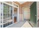 View of porch with sliding glass door and green front door at 3865 S Dayton St # 105, Aurora, CO 80014