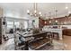 Stylish dining area with a rustic wood table and bench, open to the living room and modern kitchen at 2012 Sagerock Dr, Castle Pines, CO 80108