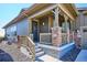 Charming covered front porch with stone accents and a well-maintained yard at 2012 Sagerock Dr, Castle Pines, CO 80108