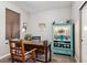 Bright home office featuring a rustic wooden desk, chair, and decorative shelving unit at 2012 Sagerock Dr, Castle Pines, CO 80108