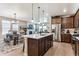 Spacious kitchen featuring a center island with bar stools, ample cabinetry, and modern appliances with pendant lighting at 2012 Sagerock Dr, Castle Pines, CO 80108