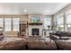 Spacious living room with a fireplace, large windows, and comfortable leather seating at 2012 Sagerock Dr, Castle Pines, CO 80108