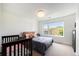 Cozy bedroom with a crib, comfortable bed, and a bright window at 3057 S University Cir, Englewood, CO 80113