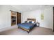 Minimalist bedroom with a cozy bed, closet with sliding barn door, and natural light at 3057 S University Cir, Englewood, CO 80113