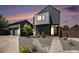 Modern home featuring dark siding, a landscaped yard with a rock pathway, and a detached garage at 3057 S University Cir, Englewood, CO 80113