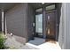 Inviting entryway with a modern wood door, decorative brick, and well-defined house numbers at 3057 S University Cir, Englewood, CO 80113