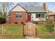 Charming brick home with a well-manicured lawn and a quaint wooden fence at 1456 Wabash St, Denver, CO 80220