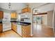 Well-lit kitchen with wood cabinets, black countertops and hardwood floors at 1456 Wabash St, Denver, CO 80220