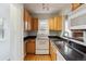Functional kitchen offering black countertops and classic wood cabinetry at 1456 Wabash St, Denver, CO 80220