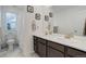 Bathroom featuring double sinks, large mirror, and walk-in shower, bathed in natural light at 1256 Elbridge Dr, Elizabeth, CO 80107