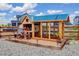 Well-maintained wooden chicken coop with run, featuring a blue roof, surrounded by gravel at 1256 Elbridge Dr, Elizabeth, CO 80107