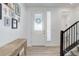 Bright entryway featuring light wood floors, staircase, and a decorative wreath on the front door at 1256 Elbridge Dr, Elizabeth, CO 80107