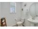 Stylish half bath with modern fixtures, decorative wall art, and a pedestal sink at 1256 Elbridge Dr, Elizabeth, CO 80107