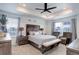 Serene main bedroom featuring a tray ceiling, large windows, a ceiling fan, and neutral decor at 1256 Elbridge Dr, Elizabeth, CO 80107