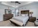 Well-lit main bedroom with a dark wood bed set, bench, and a tray ceiling at 1256 Elbridge Dr, Elizabeth, CO 80107