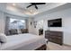 Cozy main bedroom features tray ceiling, large windows, a dresser with TV, and seating area at 1256 Elbridge Dr, Elizabeth, CO 80107