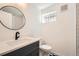 Charming bathroom features modern black hardware and a round mirror at 2065 Depew St, Edgewater, CO 80214