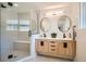 Modern bathroom featuring a glass shower, double vanity with wood cabinets and round mirrors at 2065 Depew St, Edgewater, CO 80214