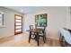 Bright dining area with hardwood floors, minimalist decor, and a view of the front door, adjacent to the kitchen at 2065 Depew St, Edgewater, CO 80214