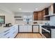 Modern kitchen featuring white cabinets, sleek countertops, stainless steel appliances, and geometric backsplash at 2065 Depew St, Edgewater, CO 80214