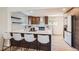 Spacious kitchen area featuring a breakfast bar, dark wood cabinets, and modern appliances with plenty of natural light at 2065 Depew St, Edgewater, CO 80214